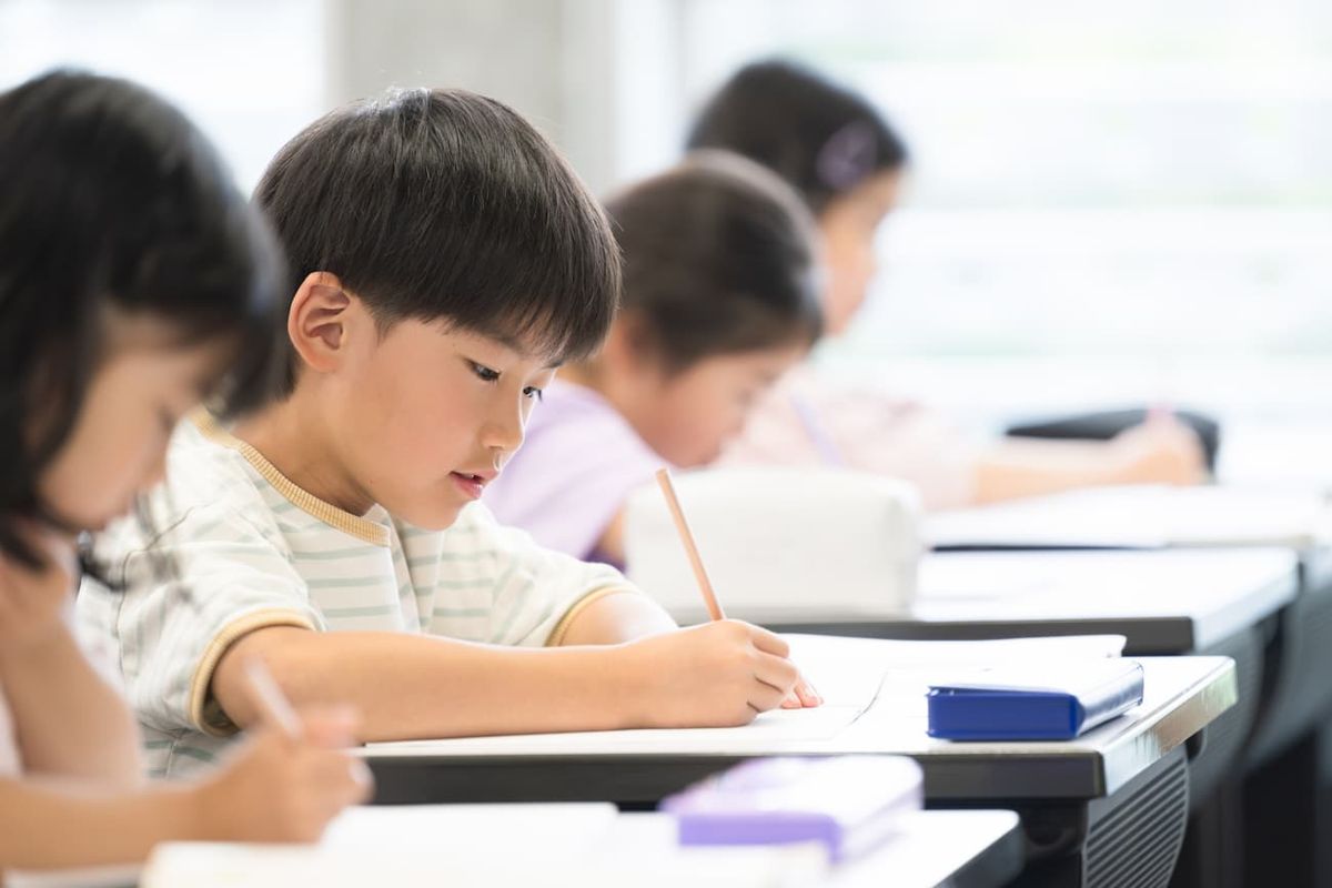授業で集中して勉強する小学生