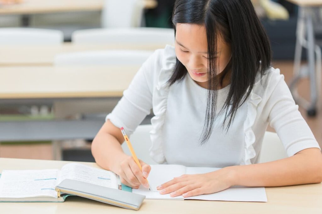 机に向かって字を書く子ども