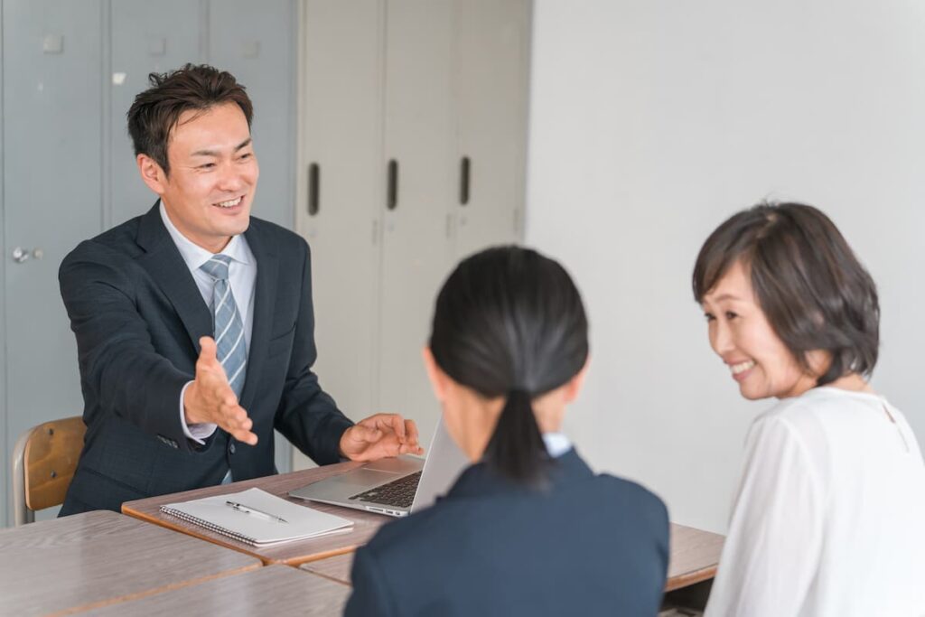 三者面談する先生と親子